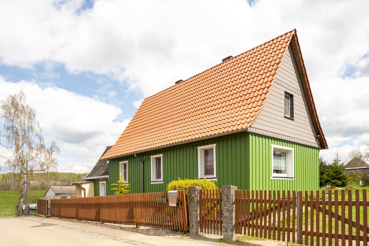 Außenansicht des grünen Ferienhauses mit rotem Ziegeldach