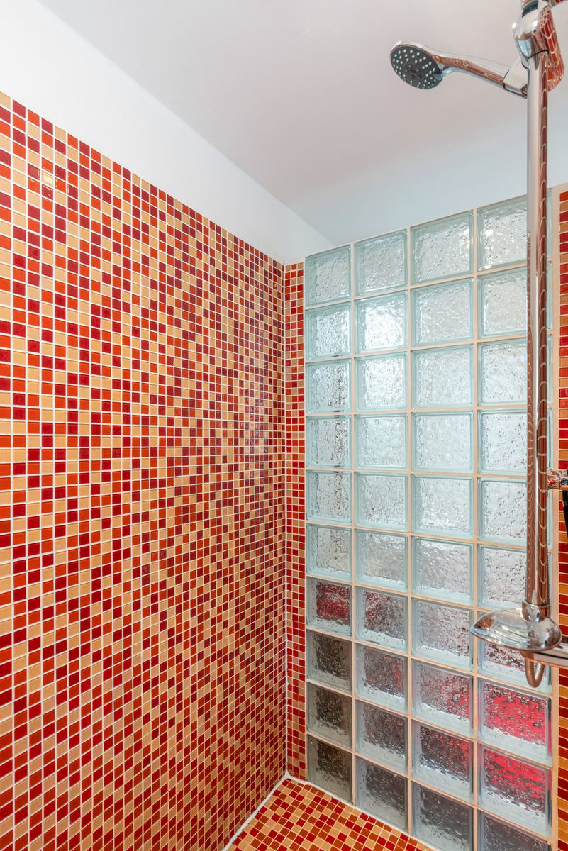 Offene ebenerdige Dusche mit rot-orangem Mosaik