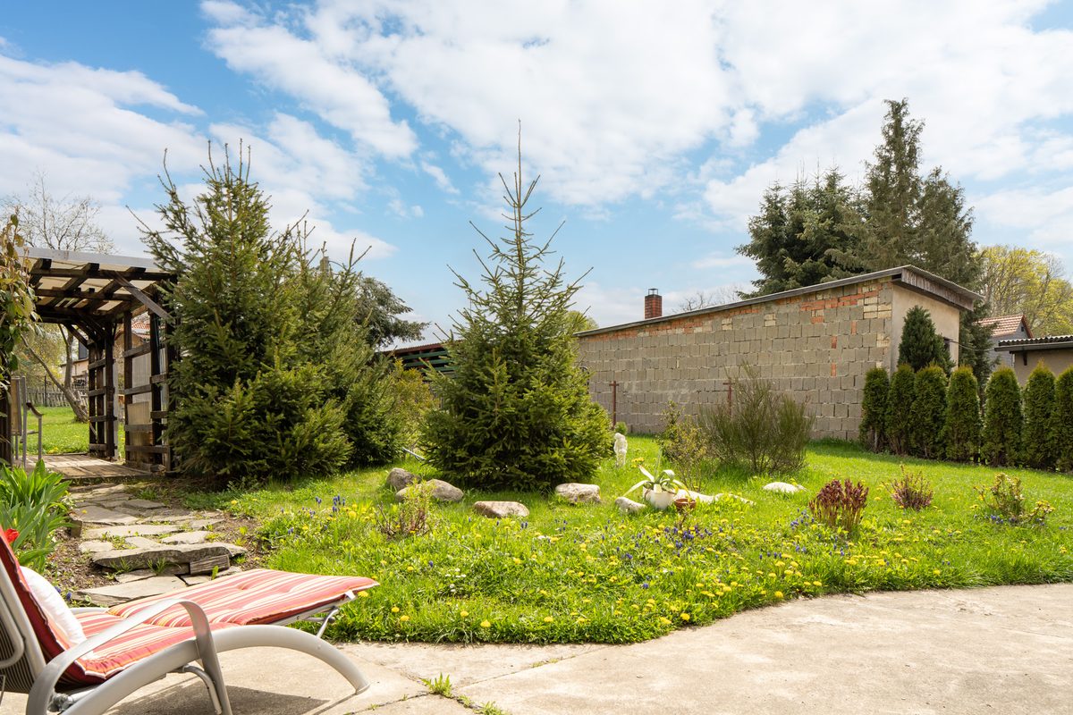 Garten mit Pergola, Bäumen und Liegestuhl