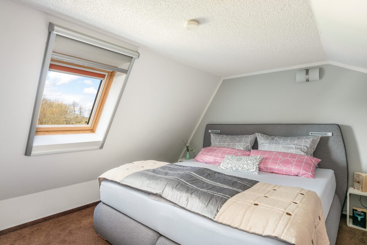 Schlafzimmer mit Doppelbett, Dachschräge und Dachfenster