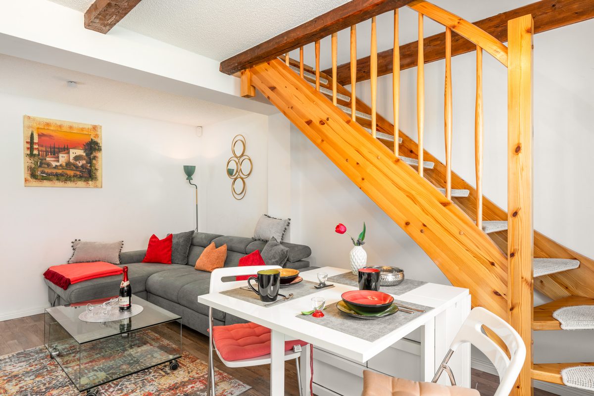Wohn-Essbereich mit Ecksofa und massiver Holztreppe