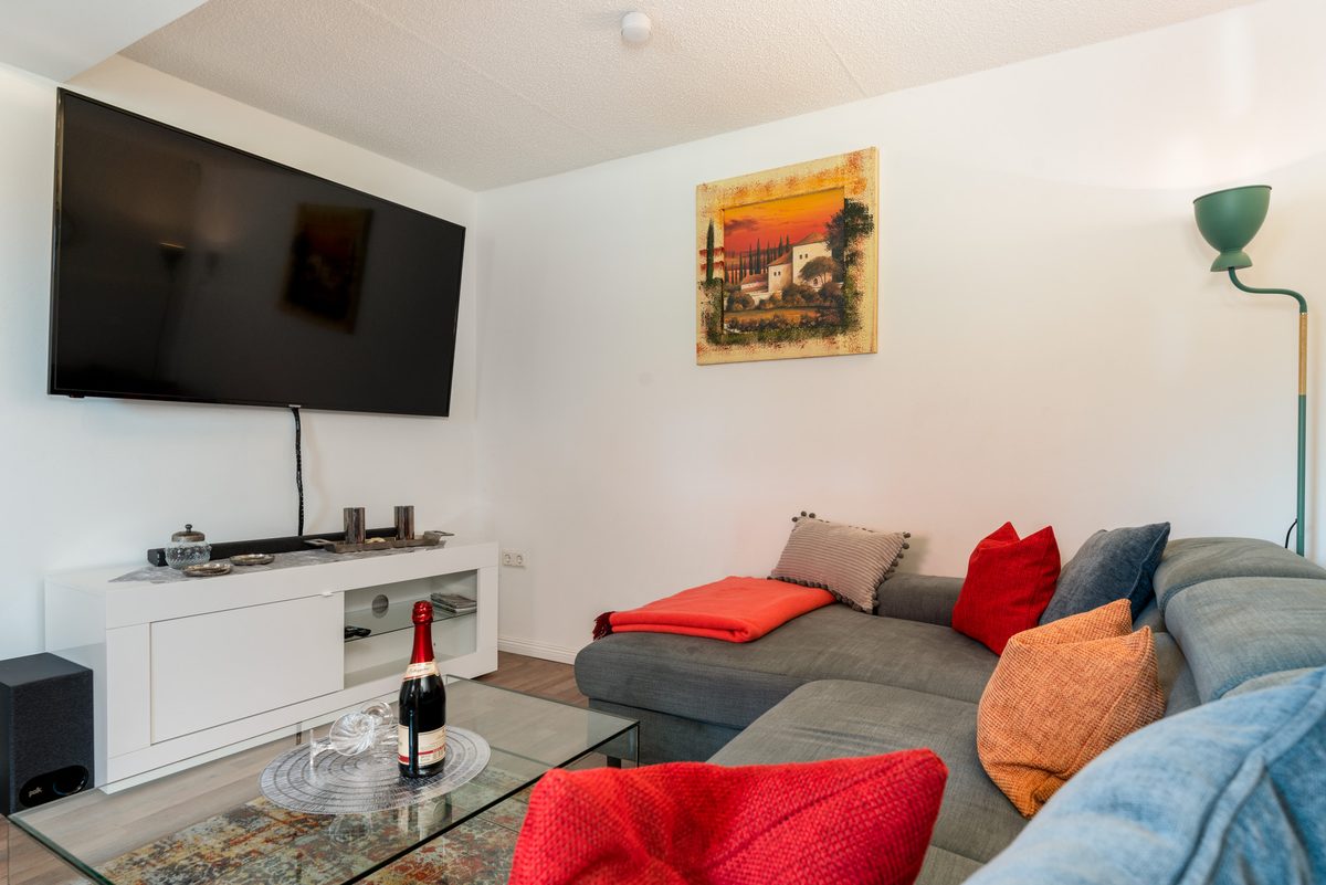 Großes Ecksofa mit Fernseher und roten Kissen